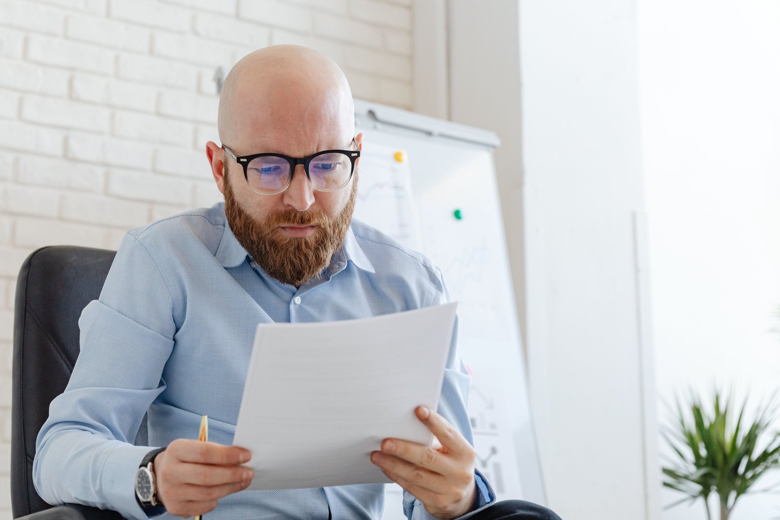 Compliance review: every control traced to documented evidence Professional carefully reviewing a printed compliance document