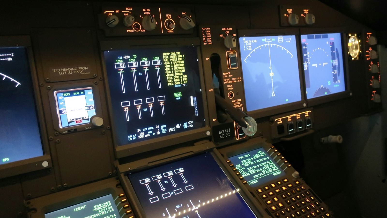 The glass cockpit of a modern aircraft, instruments and mission displays lit up