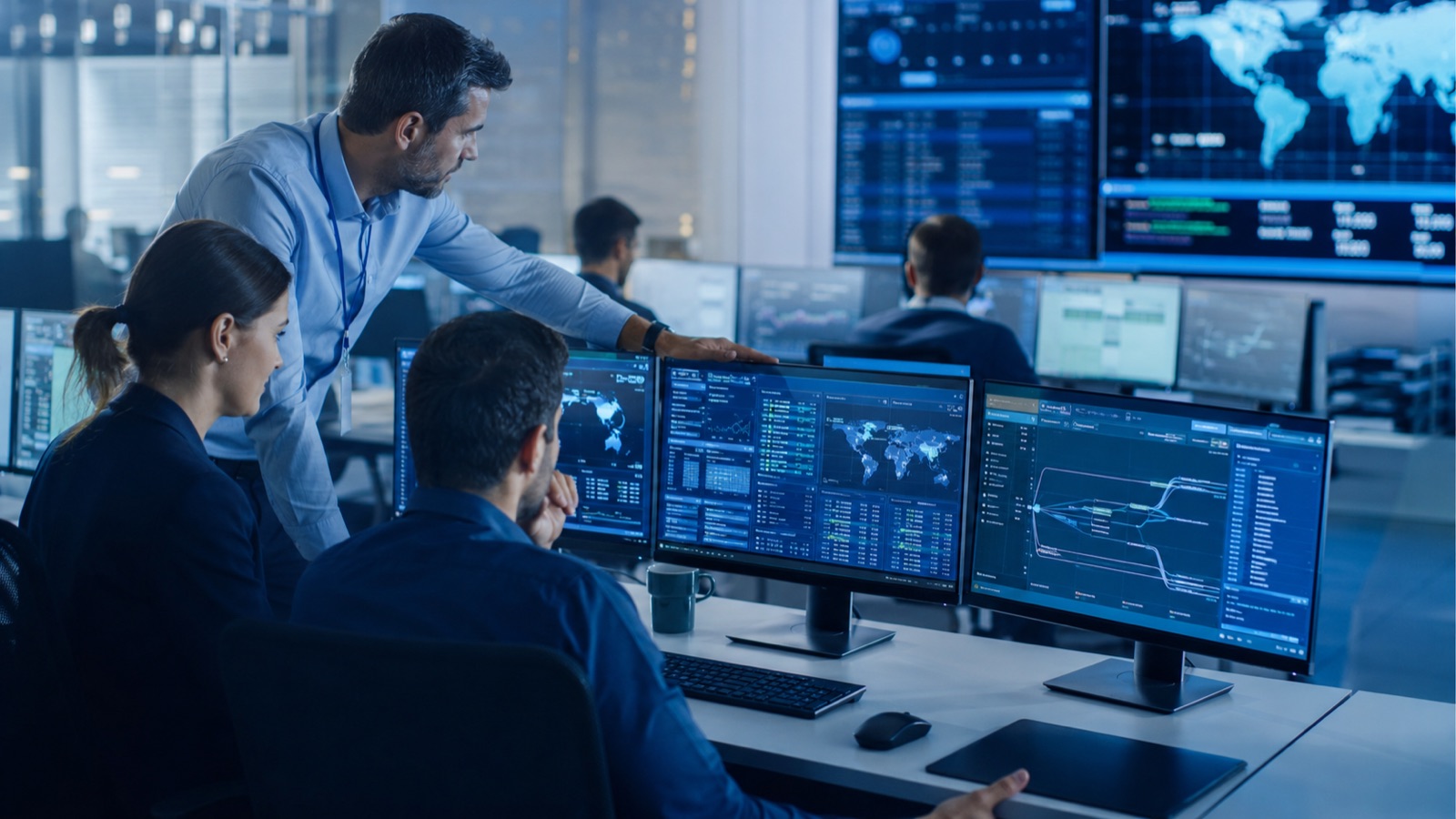 Cybersecurity operations team reviewing security dashboards in a modern command center
