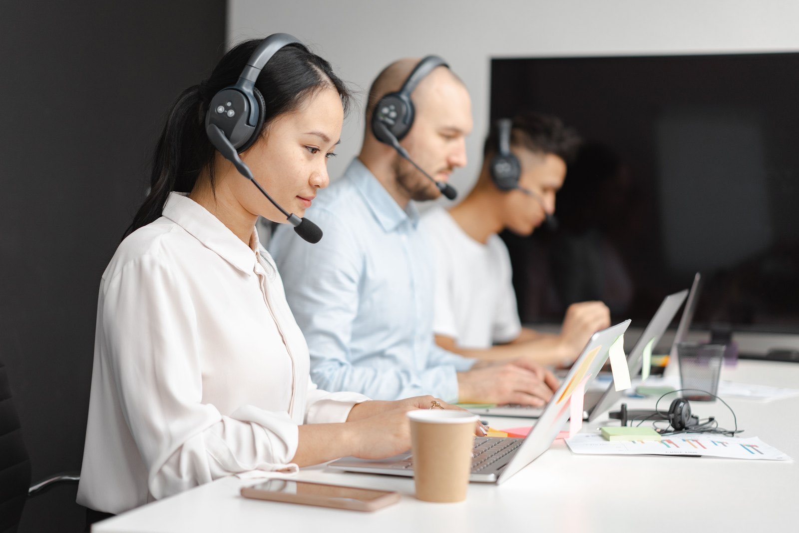 People working at laptops with headsets during remote calls
